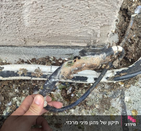 כבל מזגן פגום עם קורוזיה על הקיר